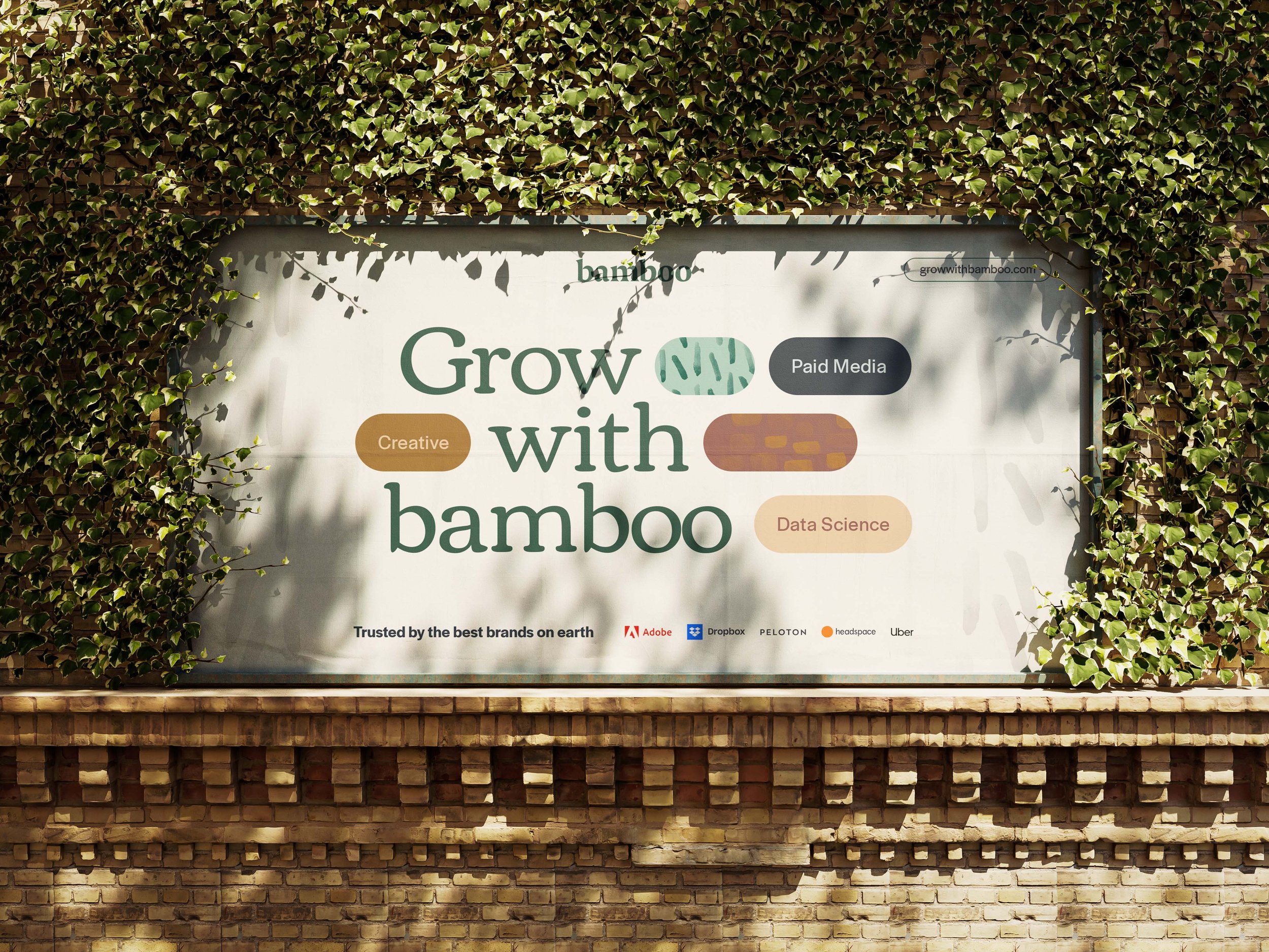 Ivy-covered billboard listing Bamboo services and clients including Adobe, Dropbox, Peloton, Headspace, and Uber.