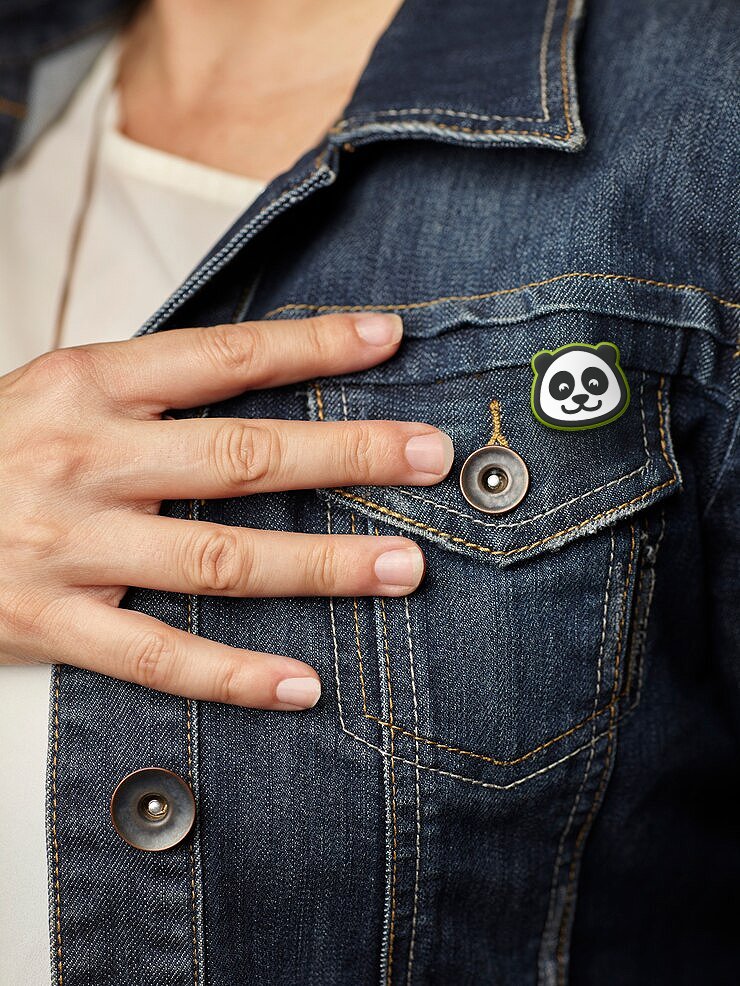 Panda pin on the chest pocket of a denim jacket.