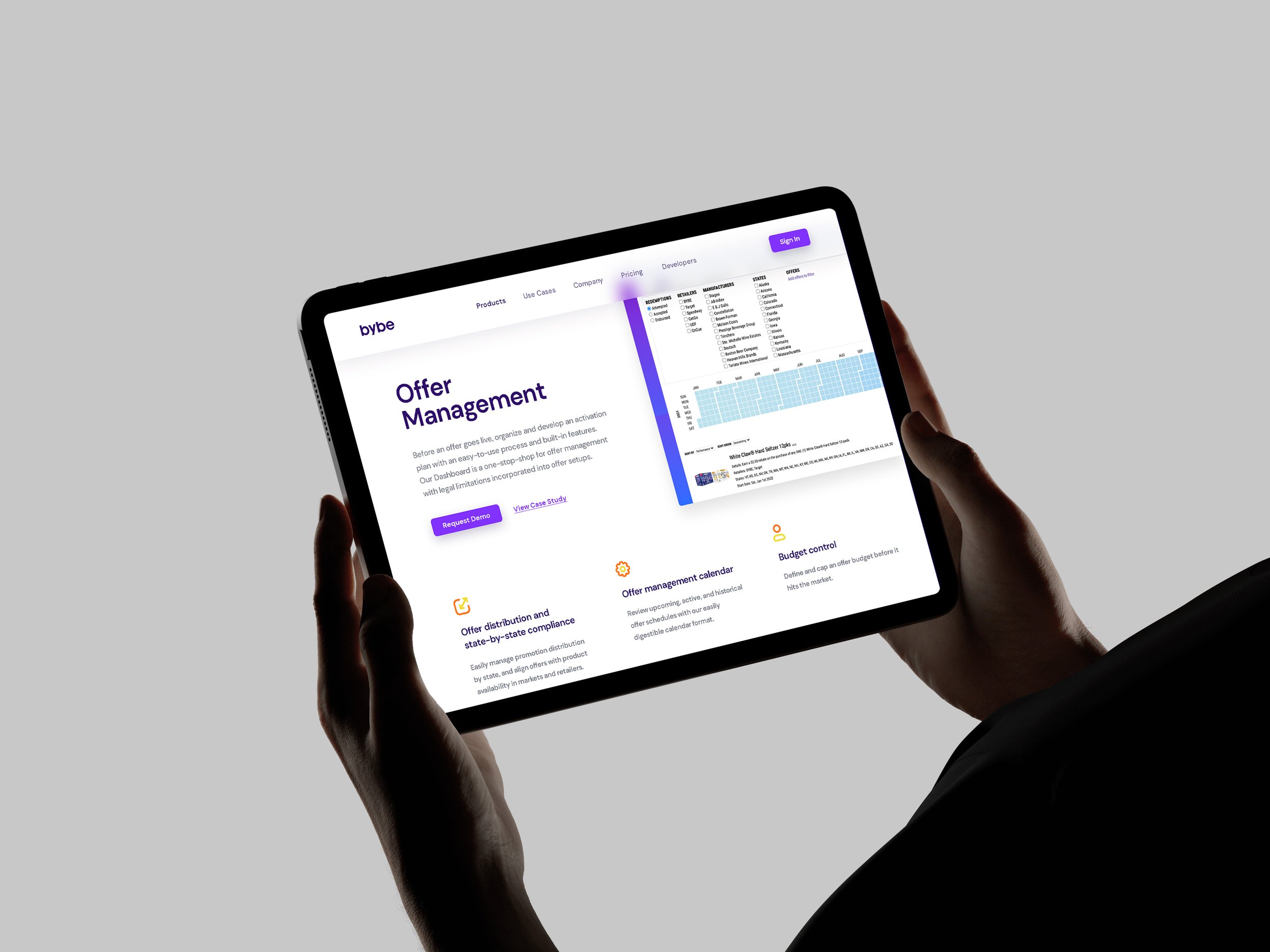 Person holding a tablet showing Bybe offer management with charts and icons.