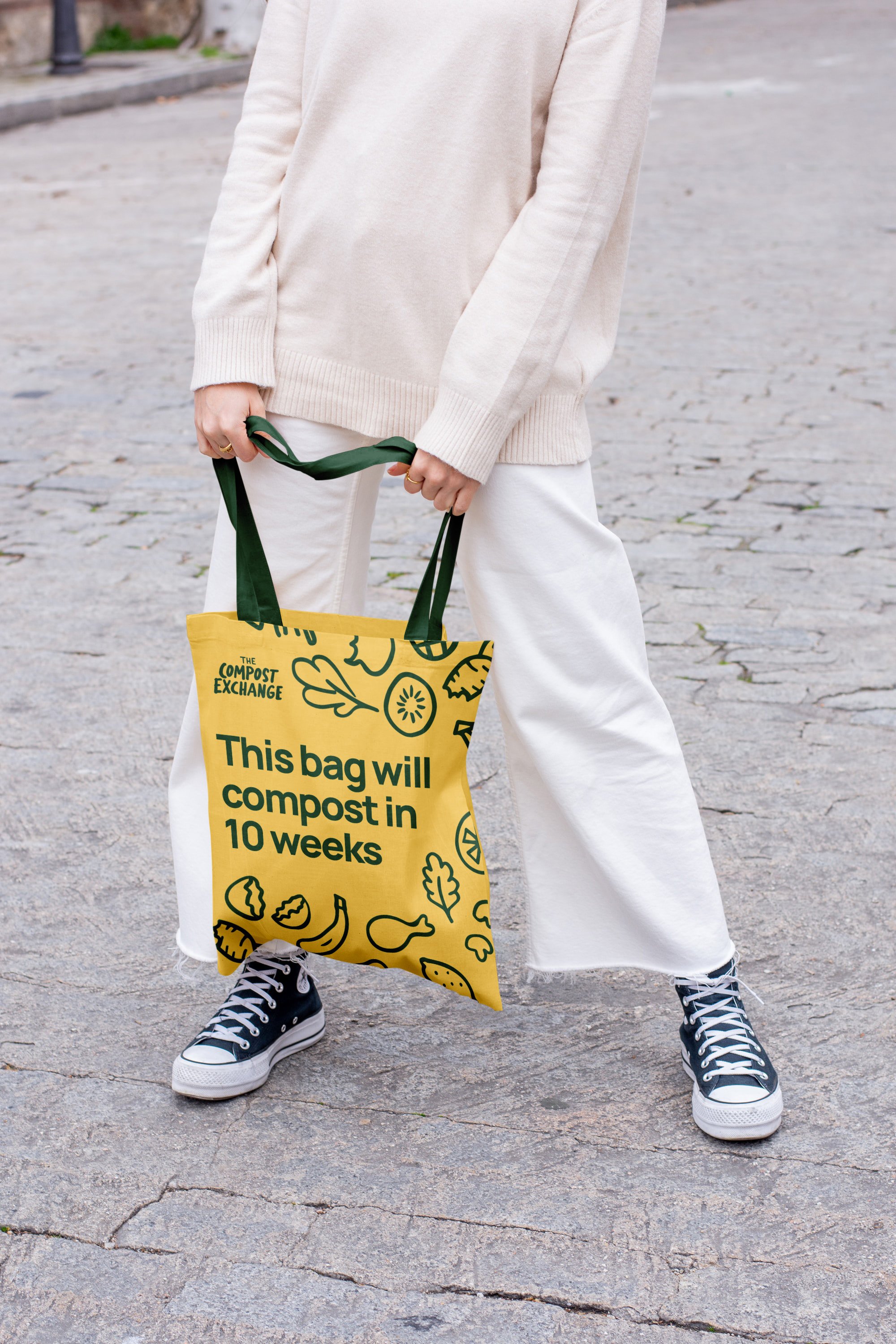 Person holding a yellow Compost Exchange tote about composting in 10 weeks.