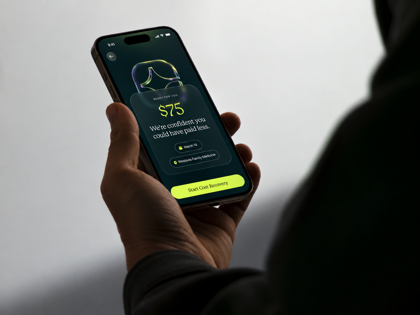 Hand holding a phone that shows a $75 healthcare cost-recovery card.
