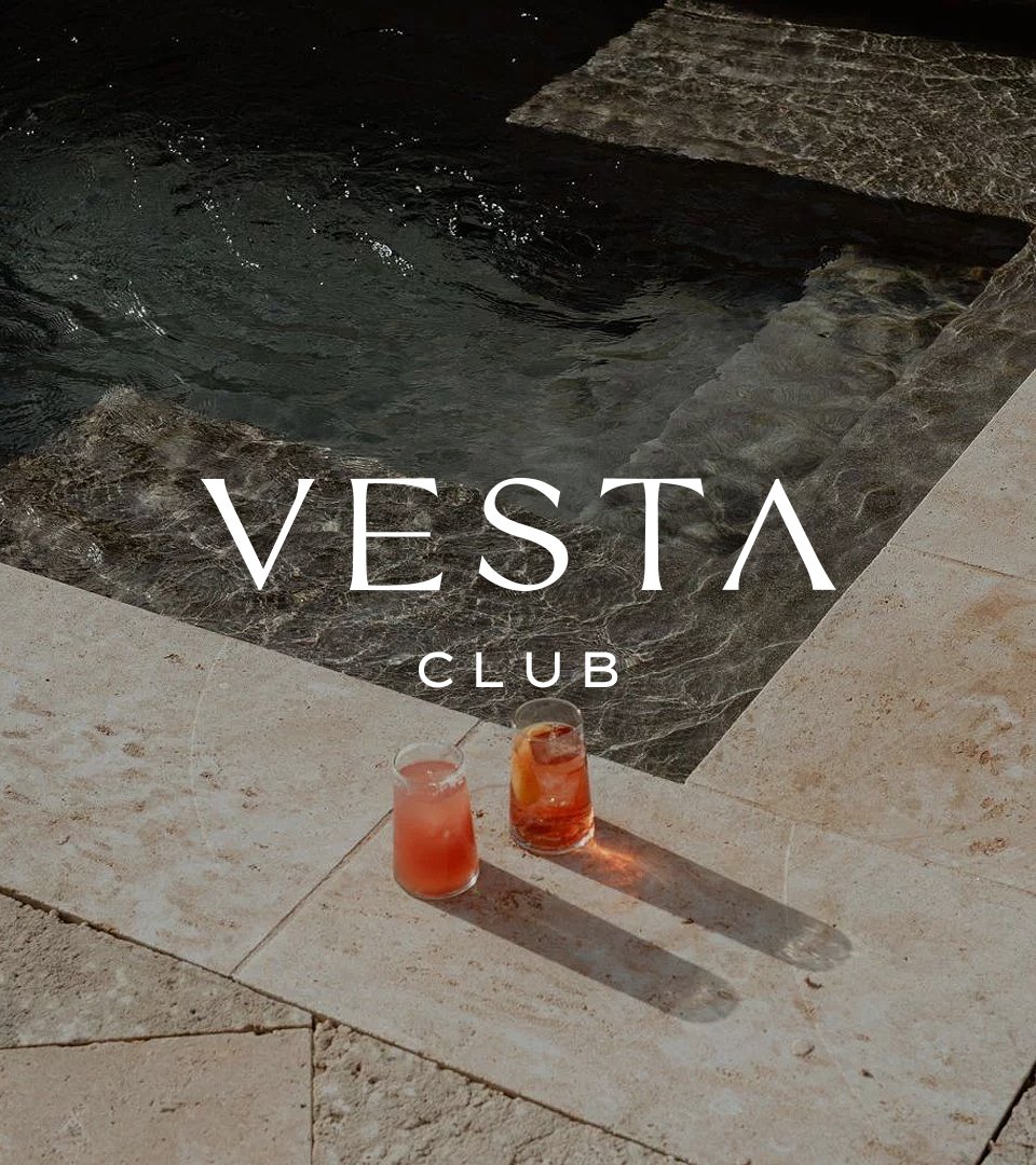 Two pink cocktails by a dark pool with the Vesta Club wordmark.