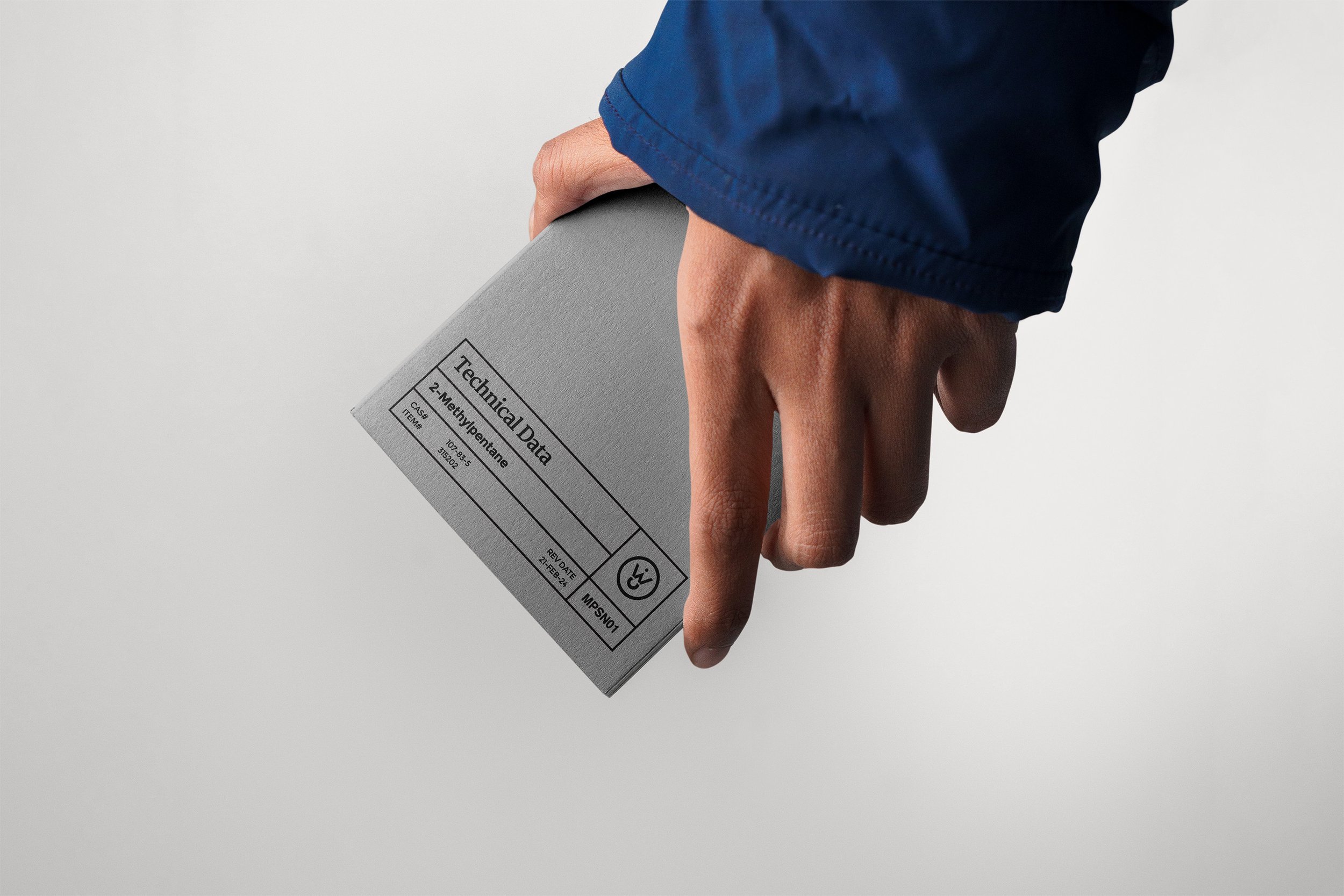 Person in a blue jacket holding a Wiley technical data booklet for 2-Methoxyphenetole.